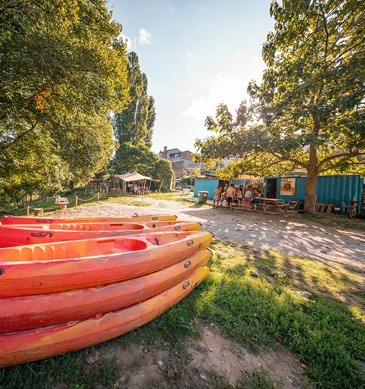 Cadre verdoyant et matériel de canoë à la base de départ de Millau Aventure à Creissels