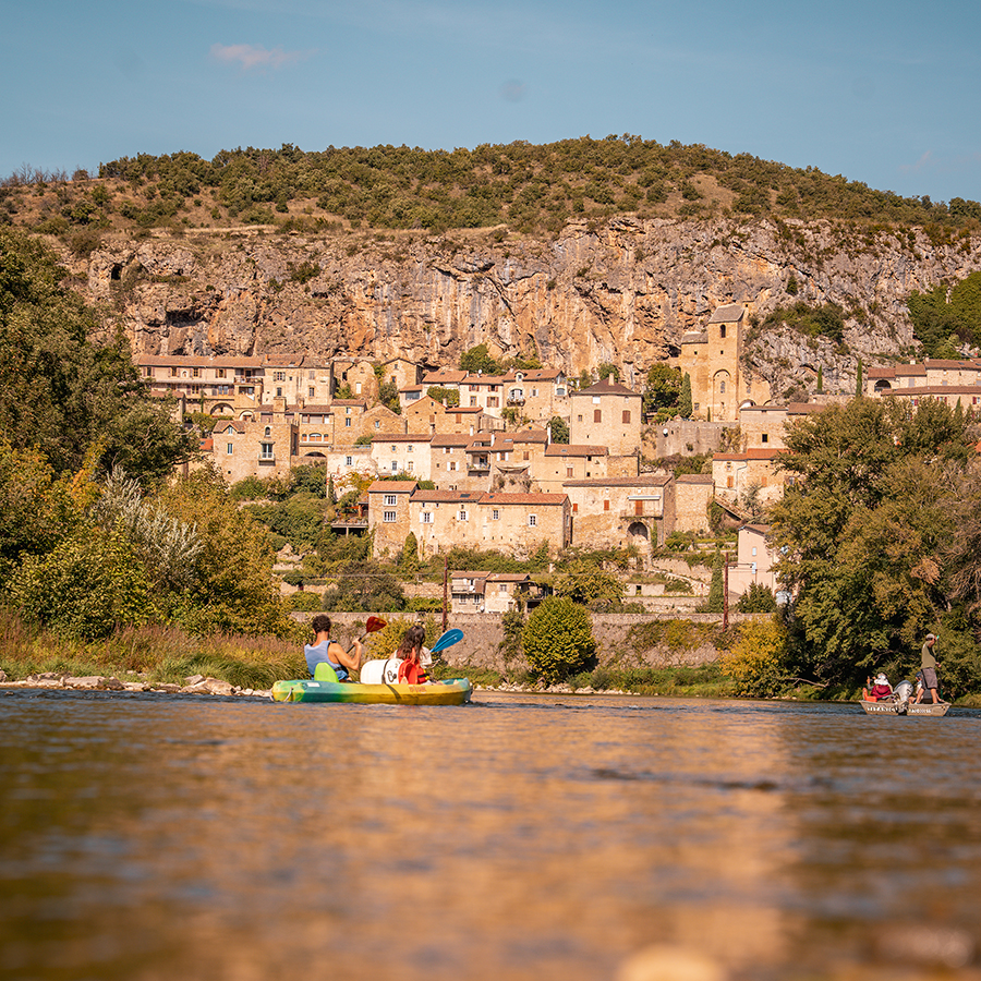 Canoës sur le Tarn avec le village troglodyte de Peyre en arrière-plan